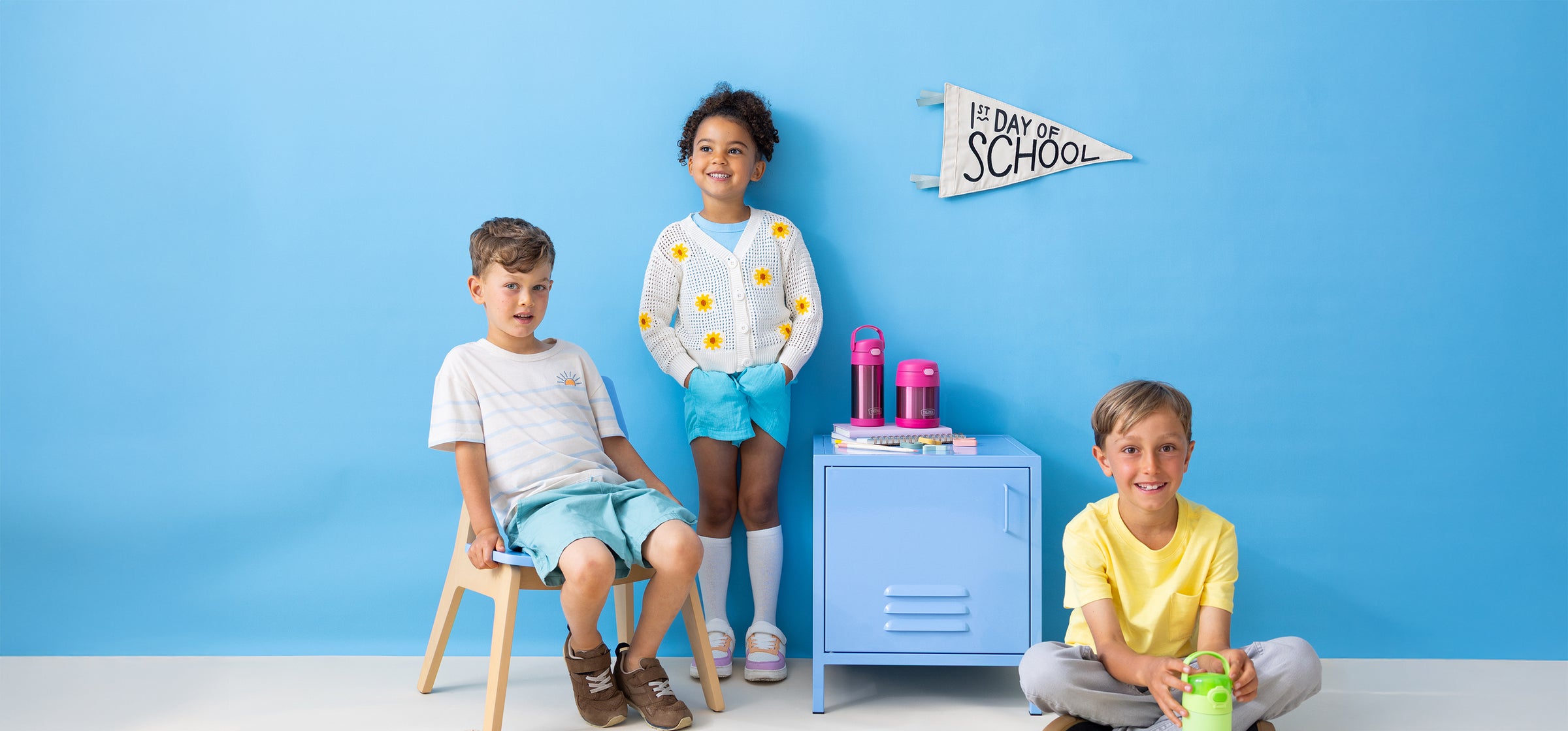 Three children with Thermos FUNtainer products against a blue background