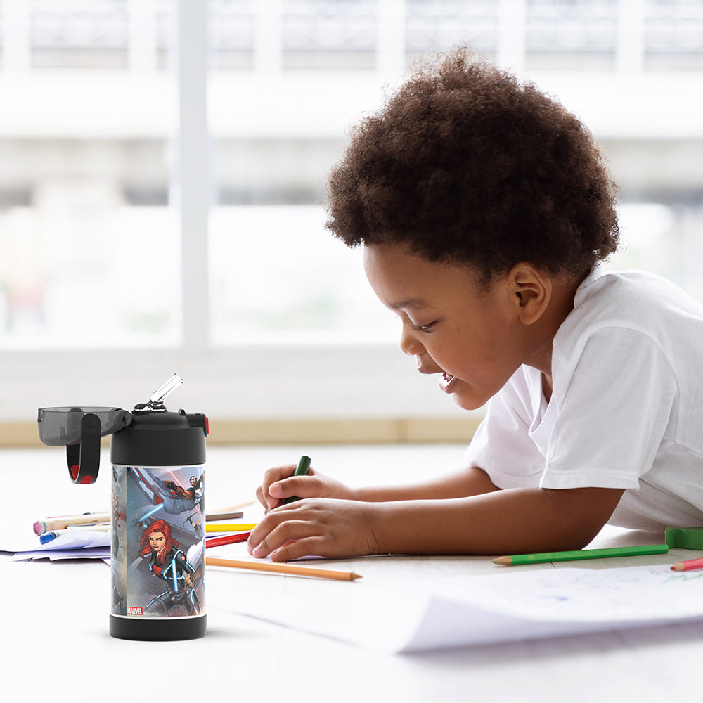 Boy sitting at a table coloring, with the 12 ounce Funtainer Avengers water bottle opened next to him.