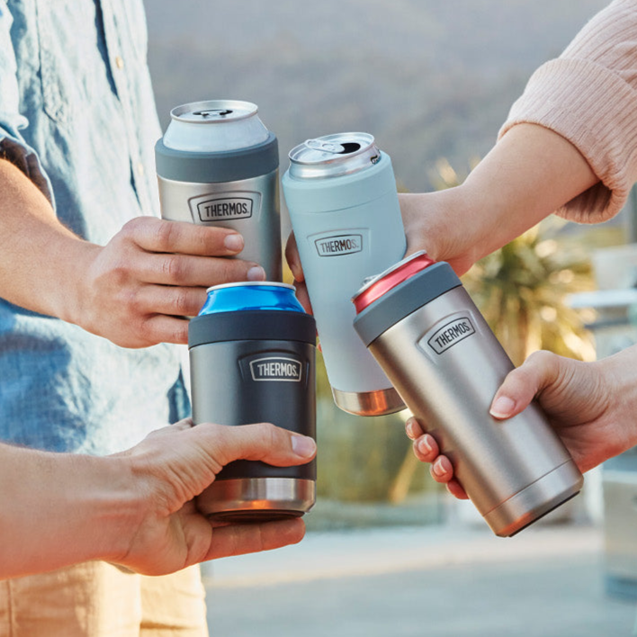 Four people holding Thermos insulated cans outdoors.