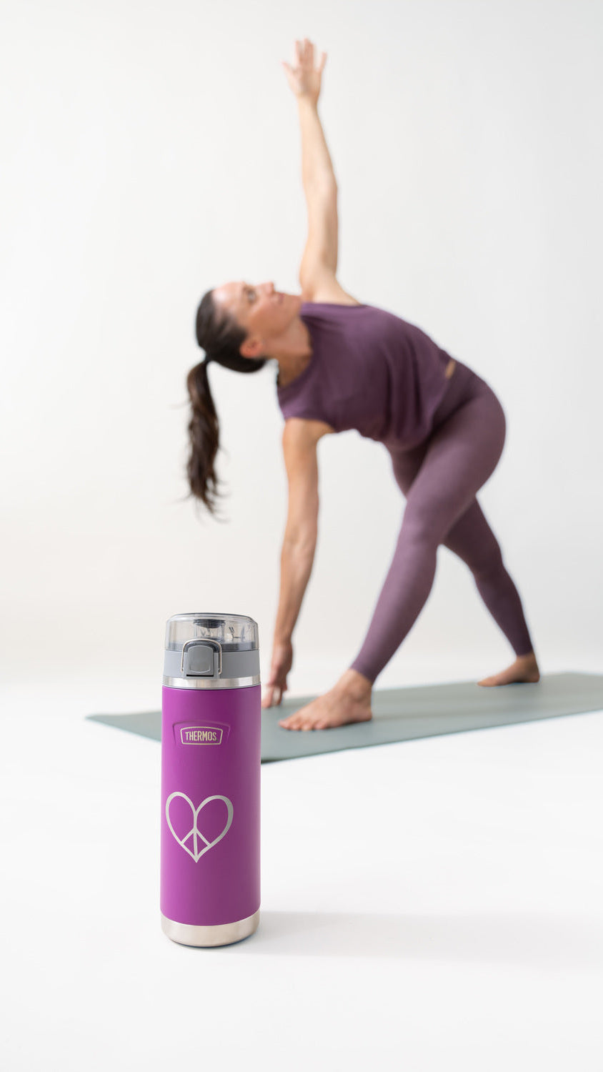 Person in purple athletic wear performing a yoga pose with a Thermos purple water bottle on a white background