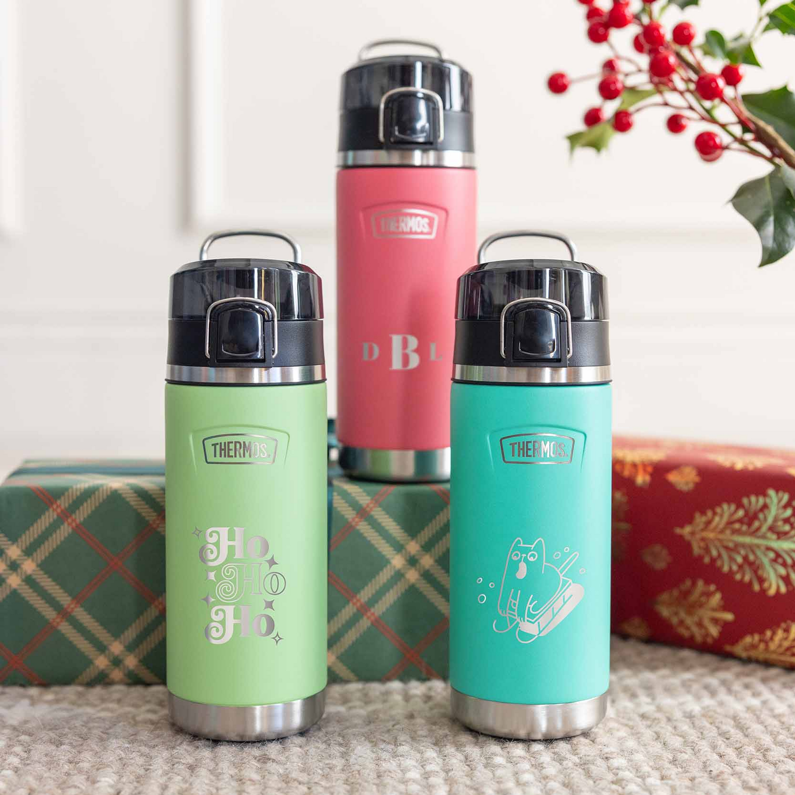 Three Thermos Water Bottles with holiday themed engraving on the bottles. 