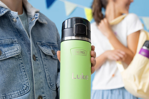 Person holding a green thermos water bottle with "Luke" engraved on the bottle.